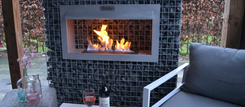 De bio ethanol haard is de perfecte haard voor buiten Een stijlvolle bio ethanol haard geïntegreerd in een schanskorf, geplaatst onder een overkapping met gezellige zithoek.